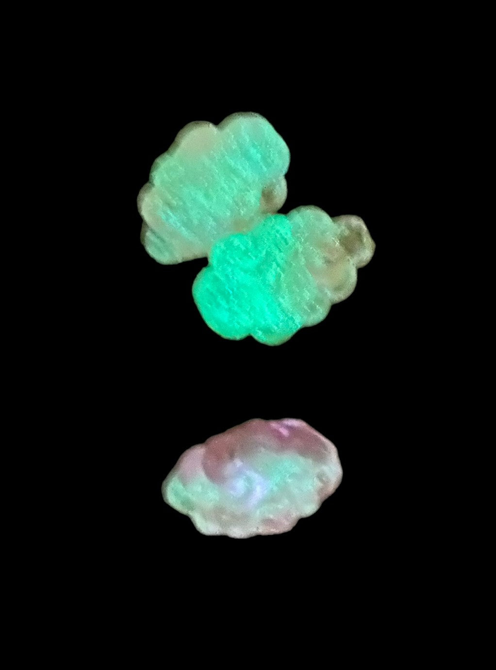 Photo of three Crazy Stinger soft beads glowing in the dark.